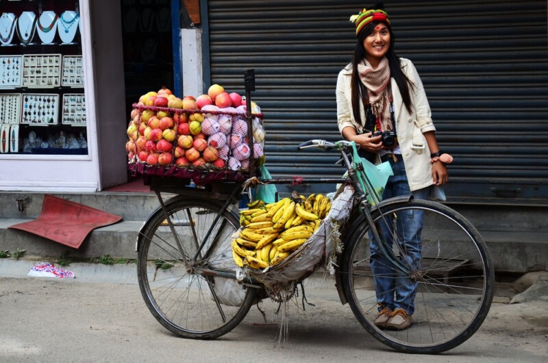 Woman with bicycle cart hawker of nepali on road sale