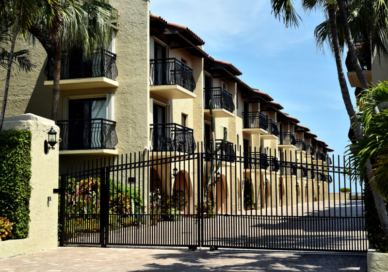 Close up image of a tan stucco gated condominium building