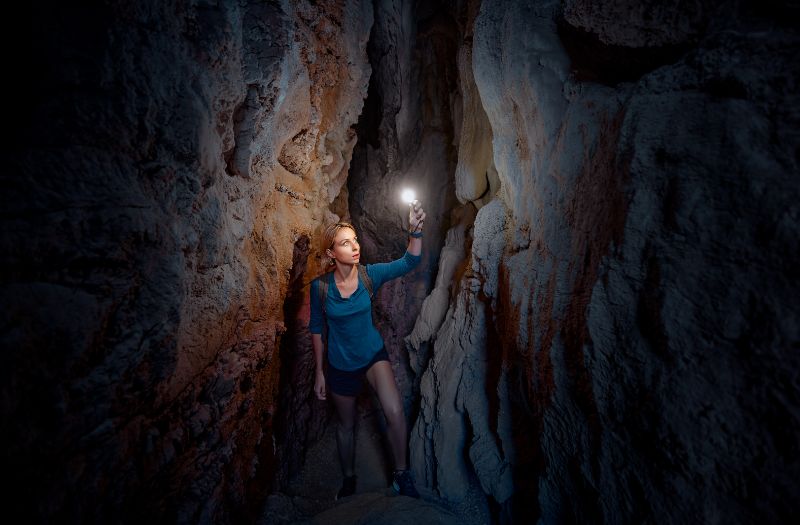 Young woman exploring a cave