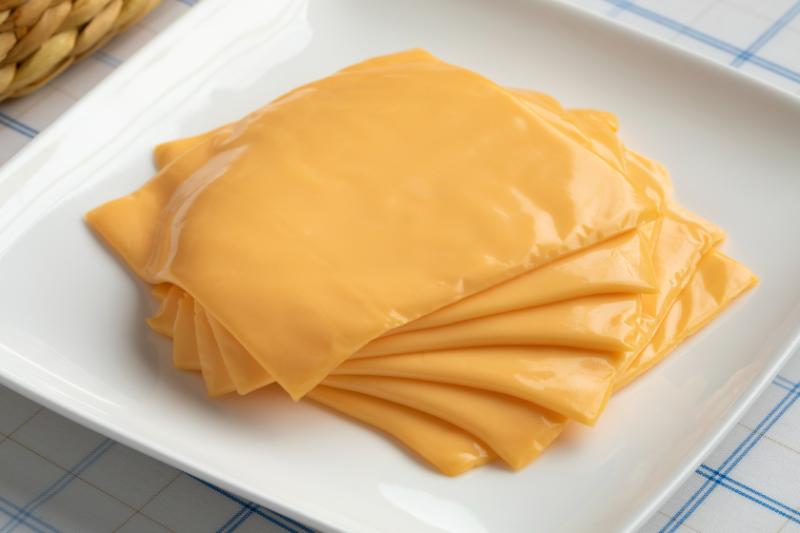 Cheddar cheese slices on a white plate