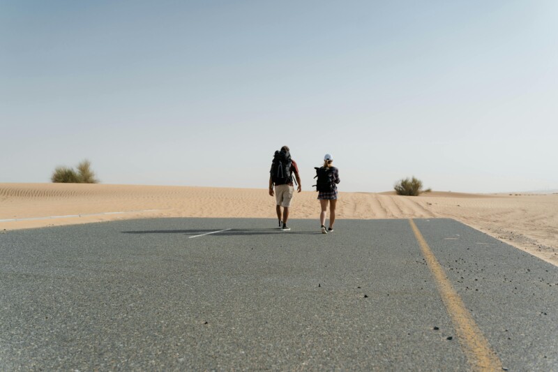 Couple backpackers walking on the road