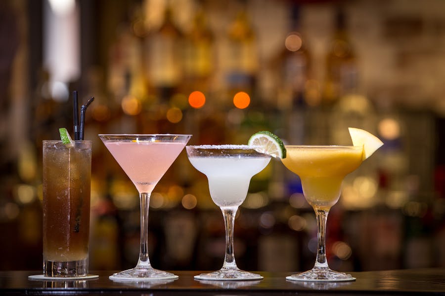 What were the popular wine coolers in the 80s? 3 Colorful Cocktails in Glasses on Bar Counter